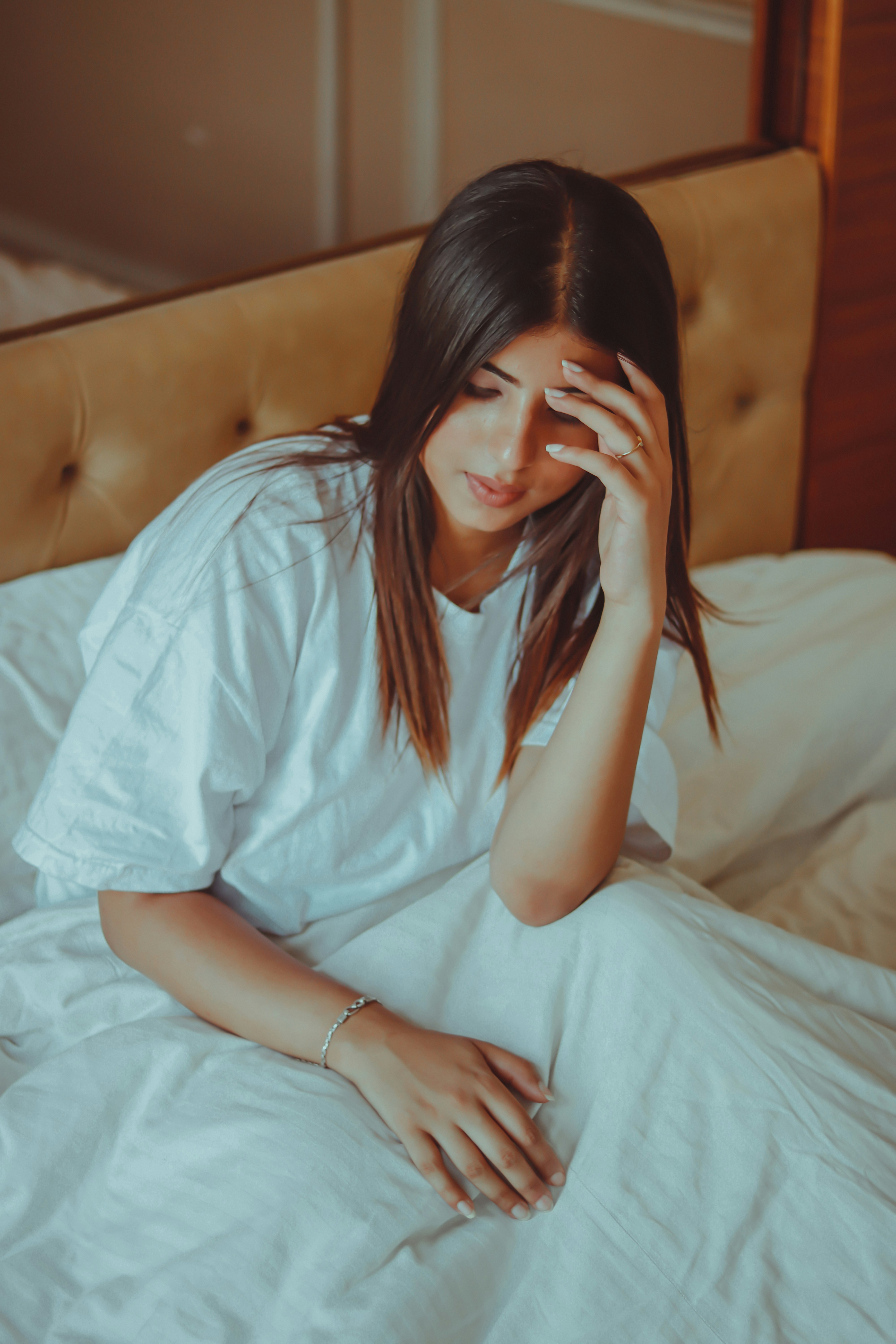 woman in white dress sitting on bed